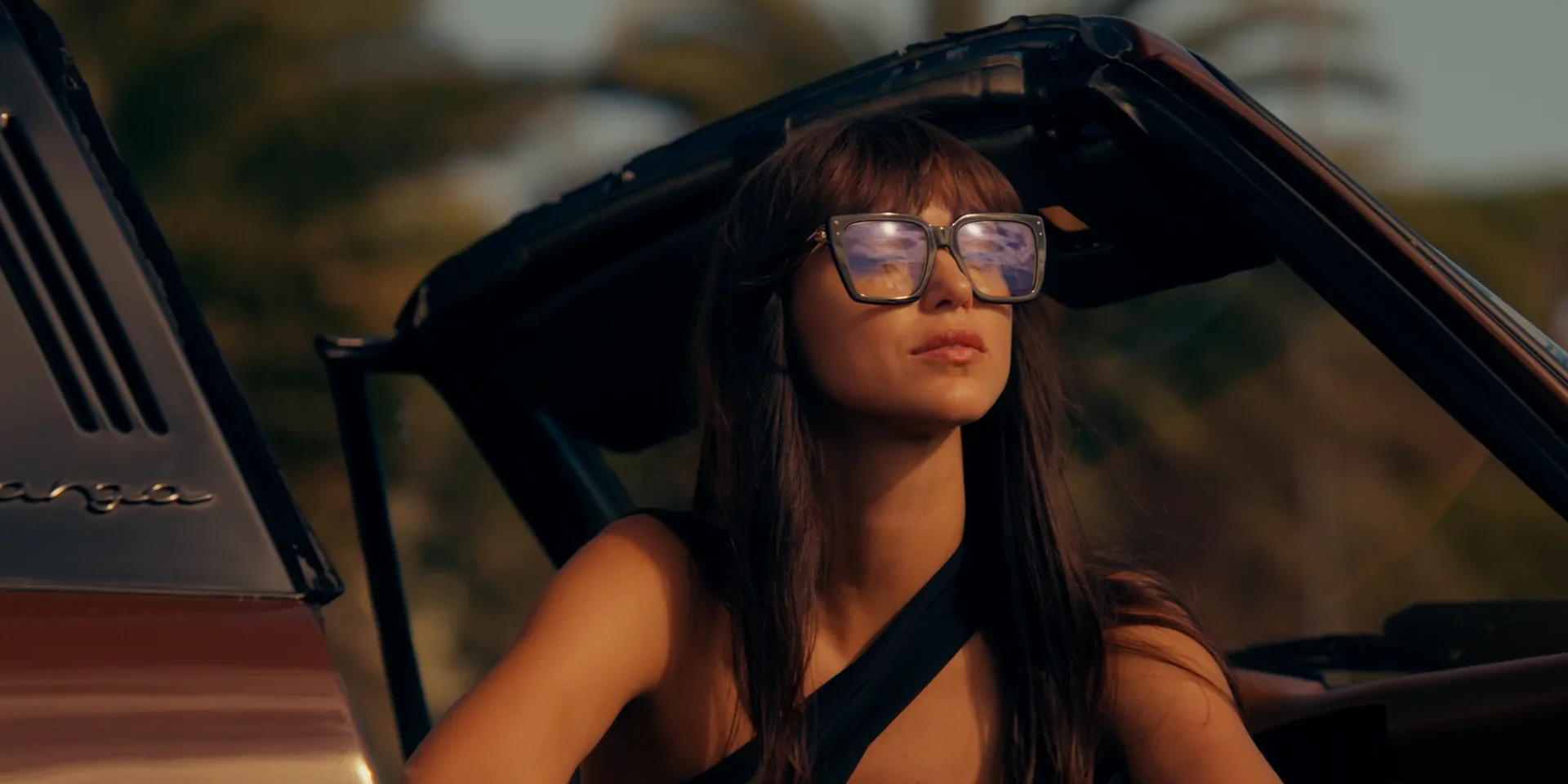 Femme portant des lunettes de vue Carrera dans un cabriolet, disponibles chez La Lunetterie à Amiens